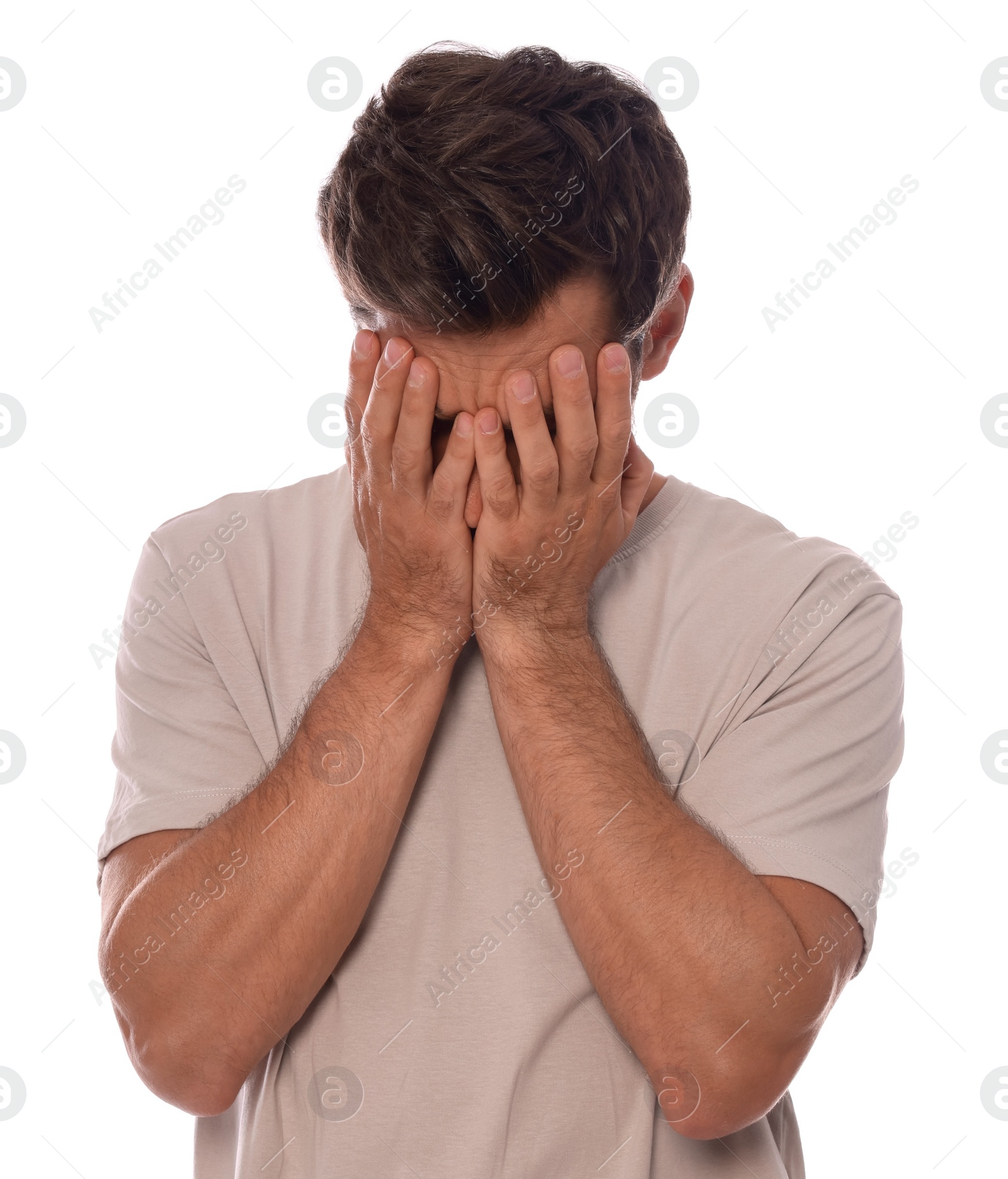 Photo of Upset man covering face with hands on white background