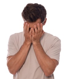 Upset man covering face with hands on white background