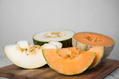 Photo of Tasty colorful ripe melons on wooden board, closeup