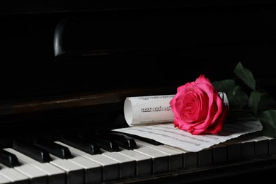 Photo of Beautiful pink rose and musical notes on piano keys