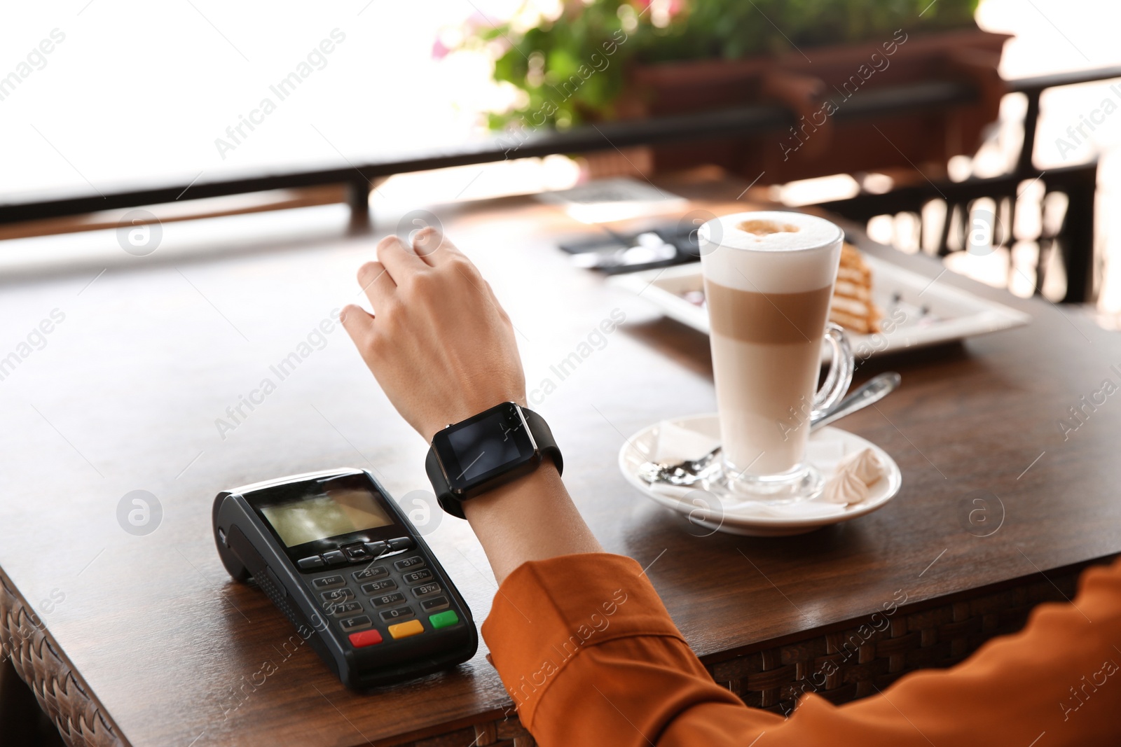 Photo of Woman making payment with smart watch in cafe, closeup