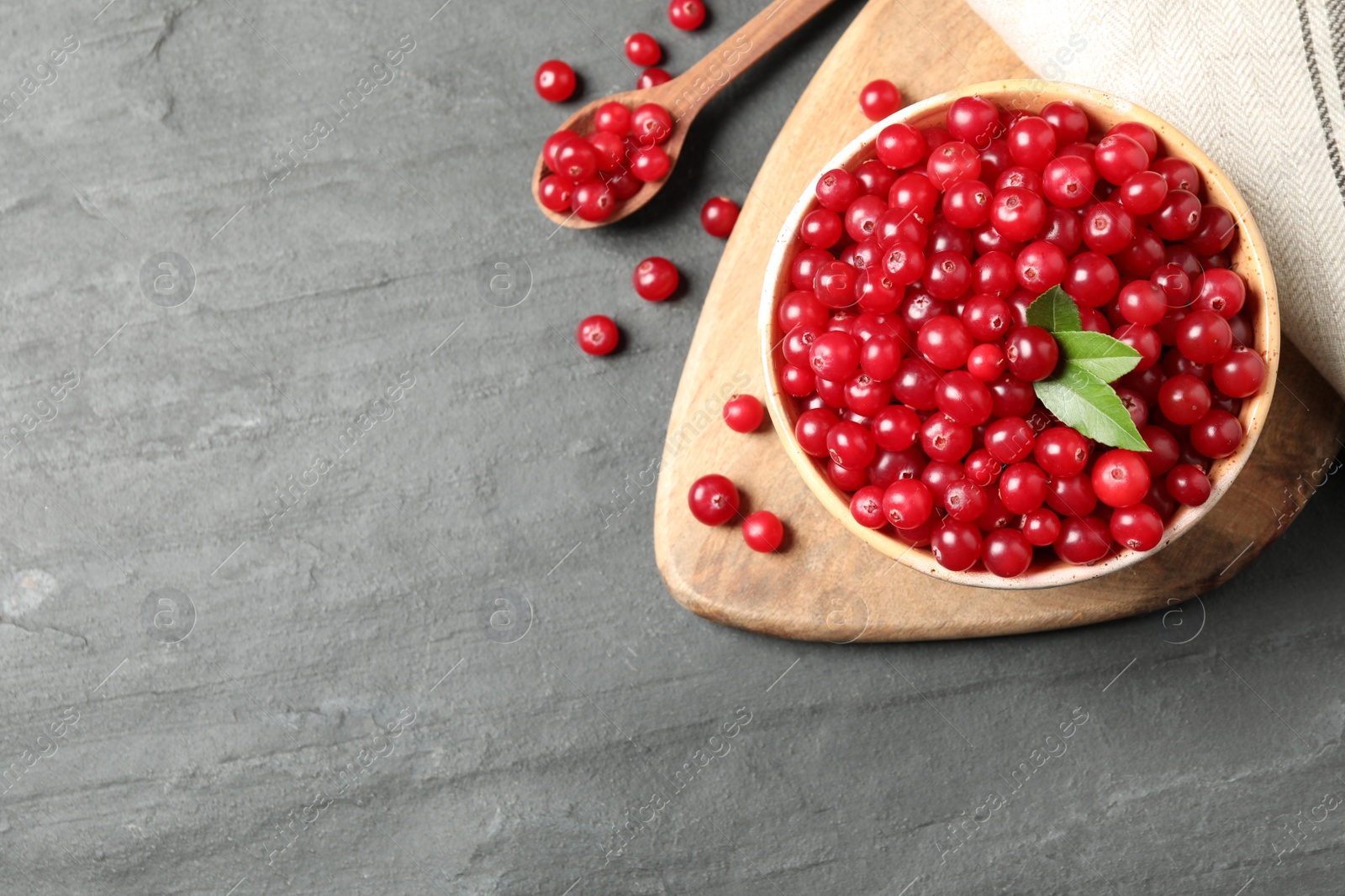 Photo of Tasty ripe cranberries on black table, flat lay. Space for text