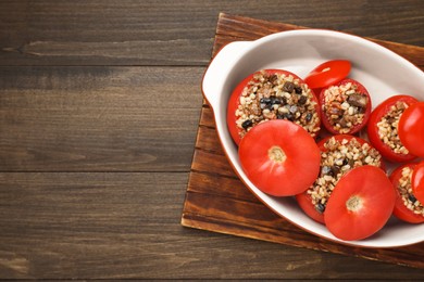 Photo of Delicious stuffed tomatoes with minced beef, bulgur and mushrooms on wooden table, top view. Space for text