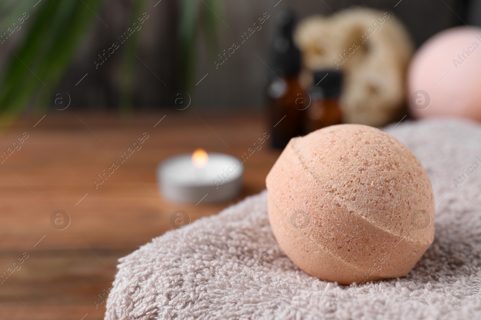 Photo of Beautiful aromatic bath bomb on towel, closeup. Space for text