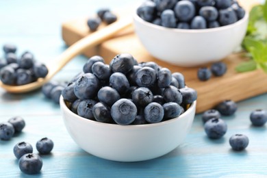 Photo of Tasty fresh blueberries on light blue table, closeup