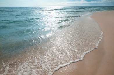 Sea waves rolling onto sandy tropical beach