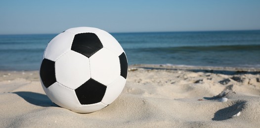 Photo of Soccer ball on beach, space for text. Football equipment