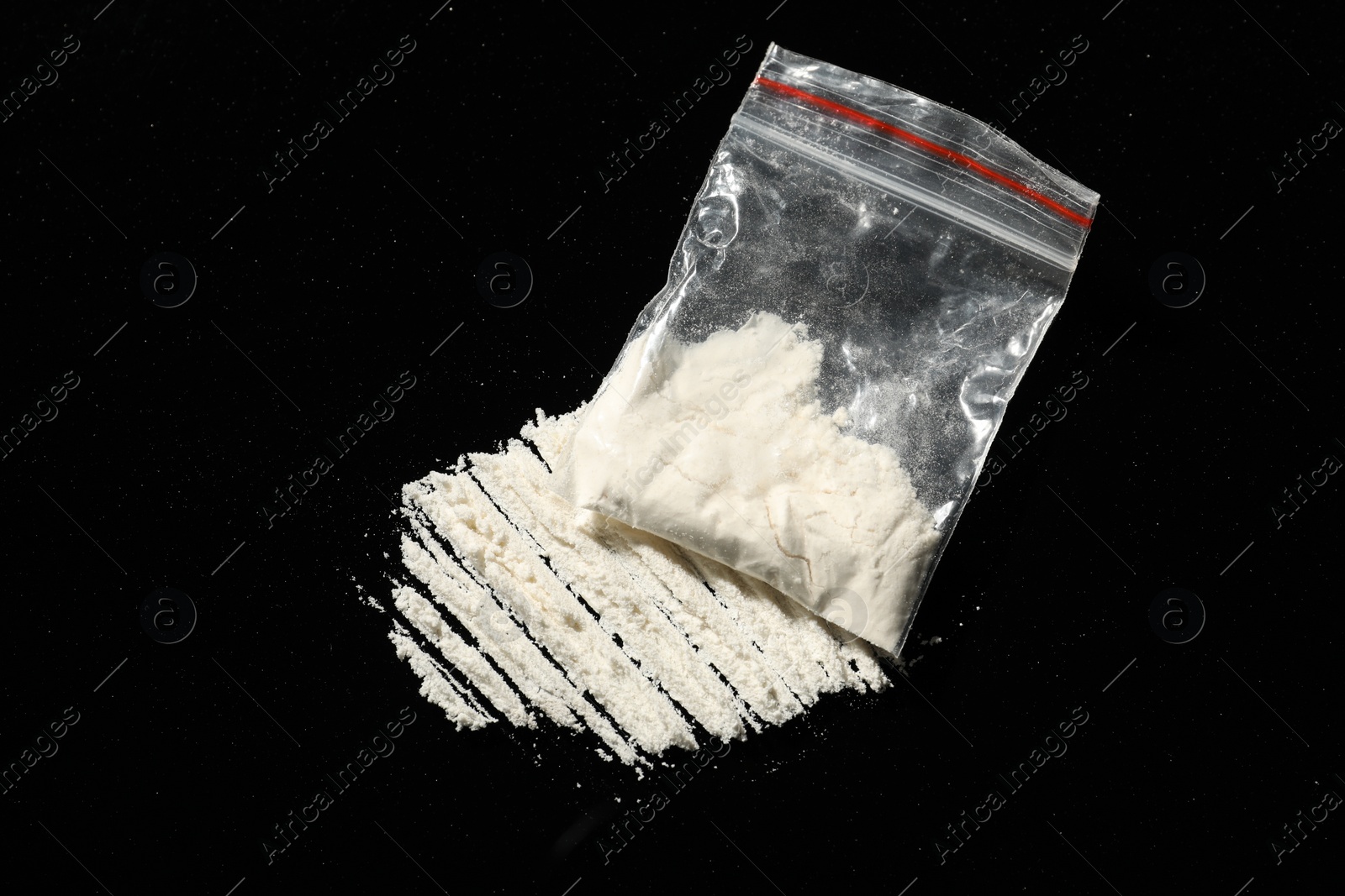 Photo of Drug addiction. Plastic bag with cocaine on black background, above view