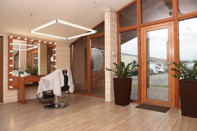 Photo of Hairdressing salon interior with large mirror and chair