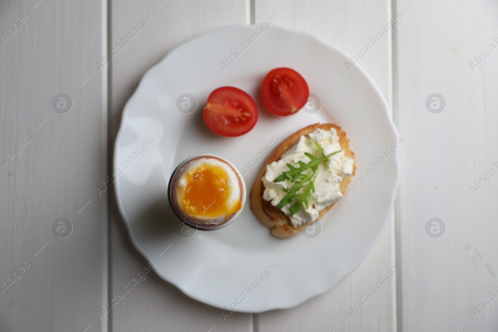 Photo of Breakfast with soft boiled egg on white wooden table, top view