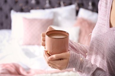 Photo of Morning of young woman with cup of hot coffee at home