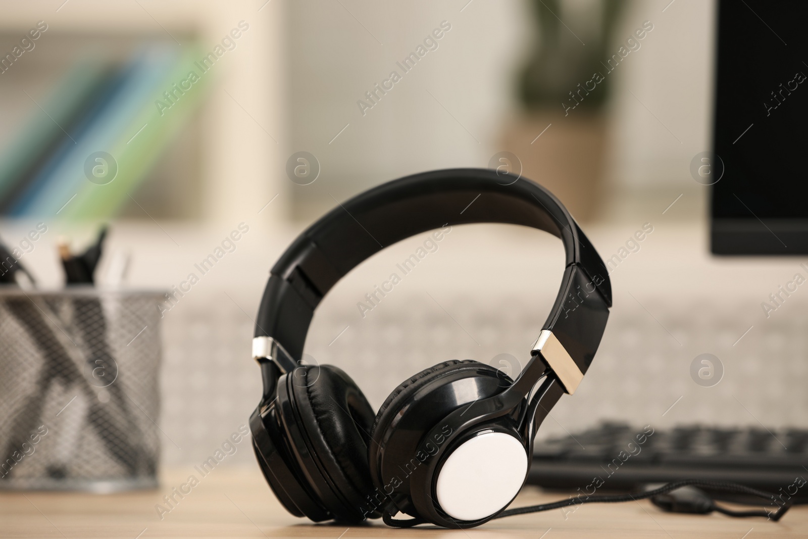 Photo of Modern headphones and computer on table indoors