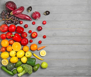 Photo of Rainbow composition with fresh vegetables and fruits on wooden background, flat lay