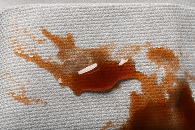 Dirty jacket with stain of coffee as background, top view