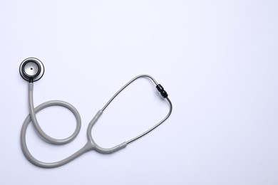 Stethoscope on white background, top view. Space for text