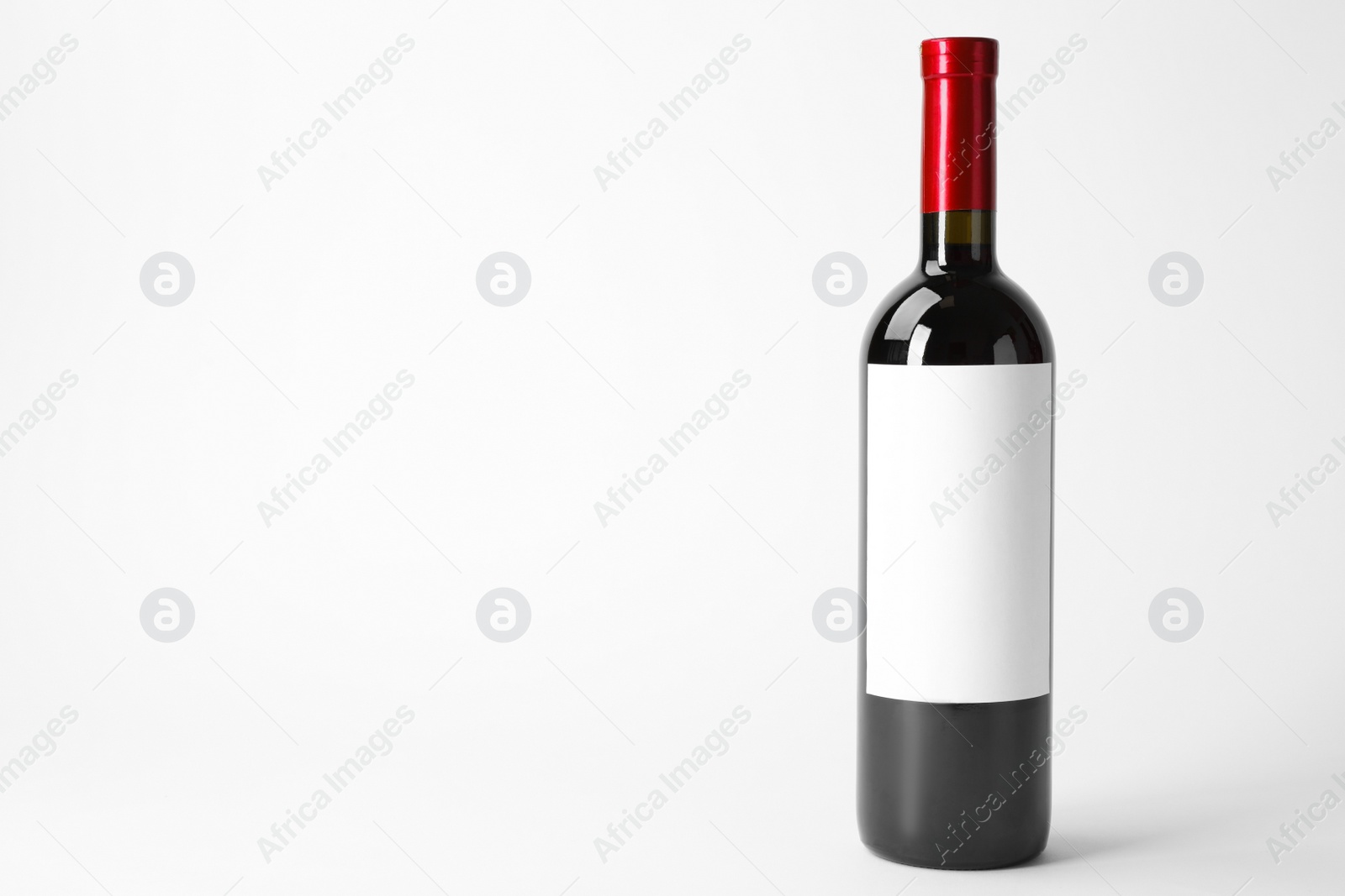 Photo of Bottle of delicious wine with blank label on white background