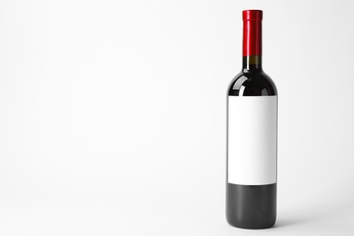 Bottle of delicious wine with blank label on white background