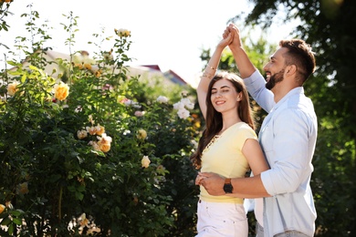 Photo of Lovely young couple dancing together in park on sunny day