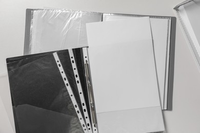 Photo of Folders with punched pockets on white table, flat lay