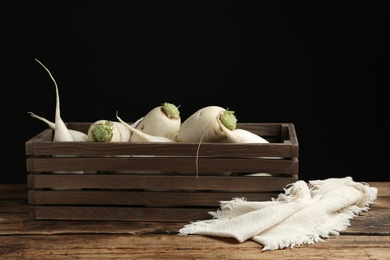 Photo of Crate with white turnips on wooden table