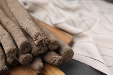Photo of Raw salsify roots on grey table, closeup. Space for text