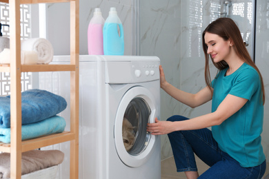 Photo of Woman near washing machine in bathroom. Laundry day