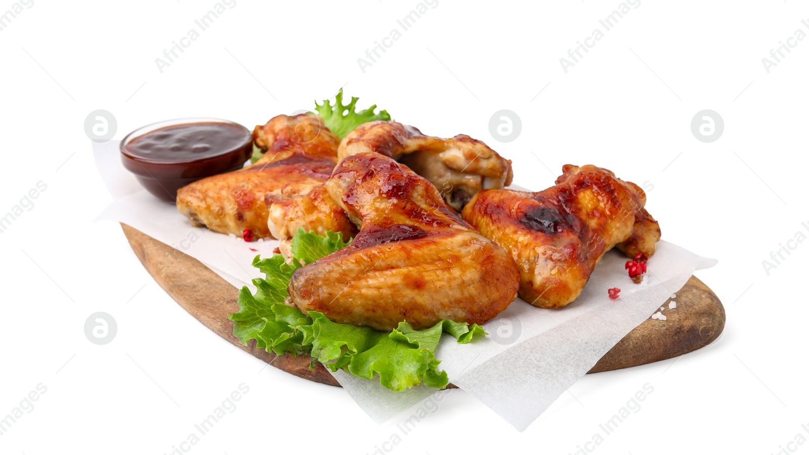 Photo of Board with marinade, chicken wings, spices and lettuce isolated on white