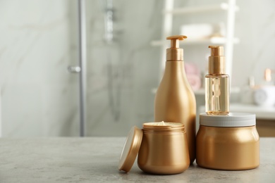 Different hair care products on table in bathroom, space for text