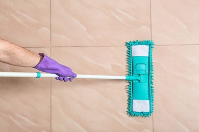 Man cleaning floor with mop, top view