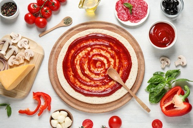 Photo of Flat lay composition with pizza crust and ingredients on white wooden table