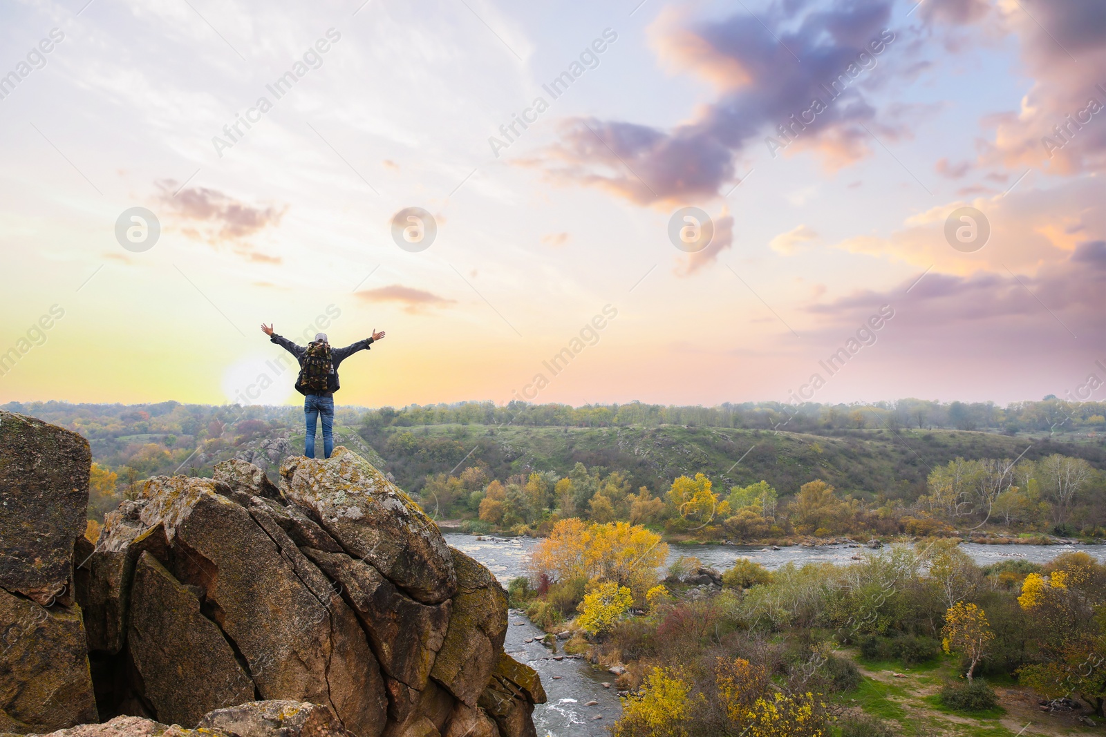 Photo of Hiker with travel backpack enjoying beautiful view near mountain river, back view