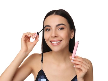 Photo of Beautiful young woman applying mascara on white background