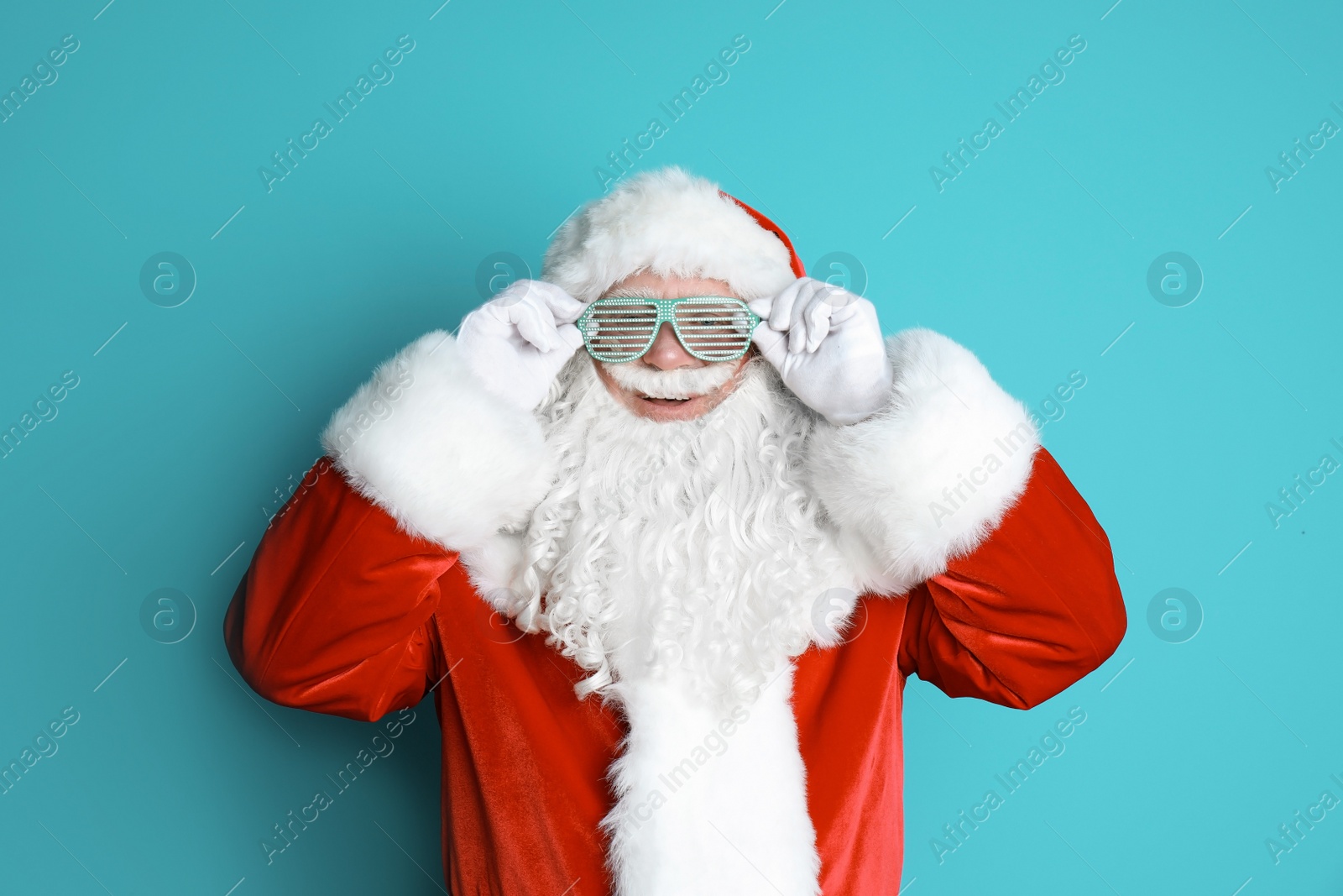 Photo of Authentic Santa Claus wearing funny glasses on color background