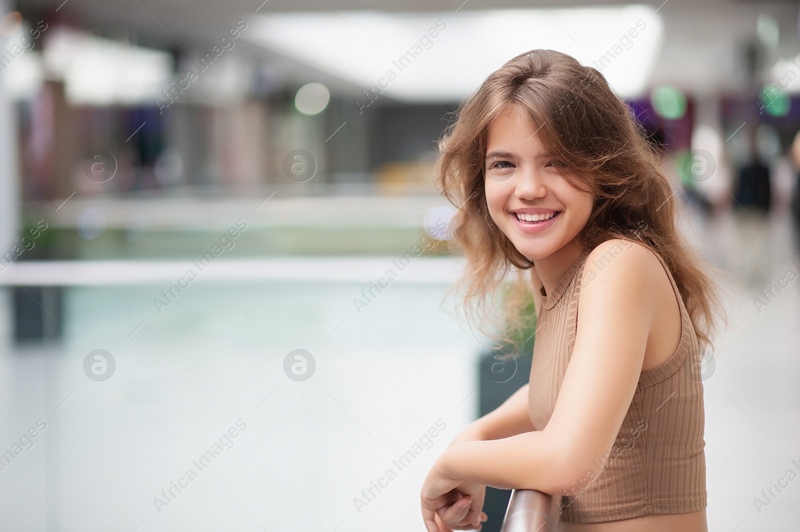 Photo of Portrait of beautiful teenage girl in shopping mall. Space for text