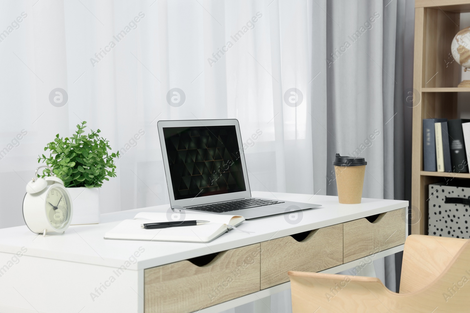 Photo of Workplace with modern laptop on desk at home