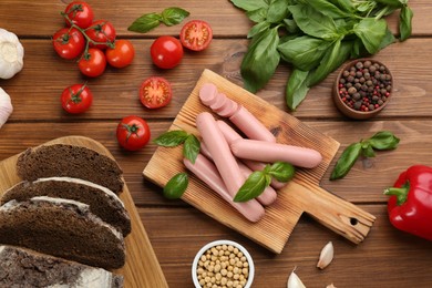 Photo of Flat lay composition with vegetarian sausages and vegetables on wooden table