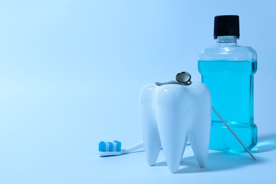 Photo of Composition with tooth shaped holder, mouthwash, brush and mirror on color background, space for text. Dentist consultation