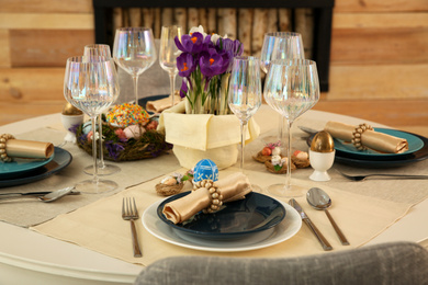 Photo of Festive Easter table setting with decorated eggs in kitchen