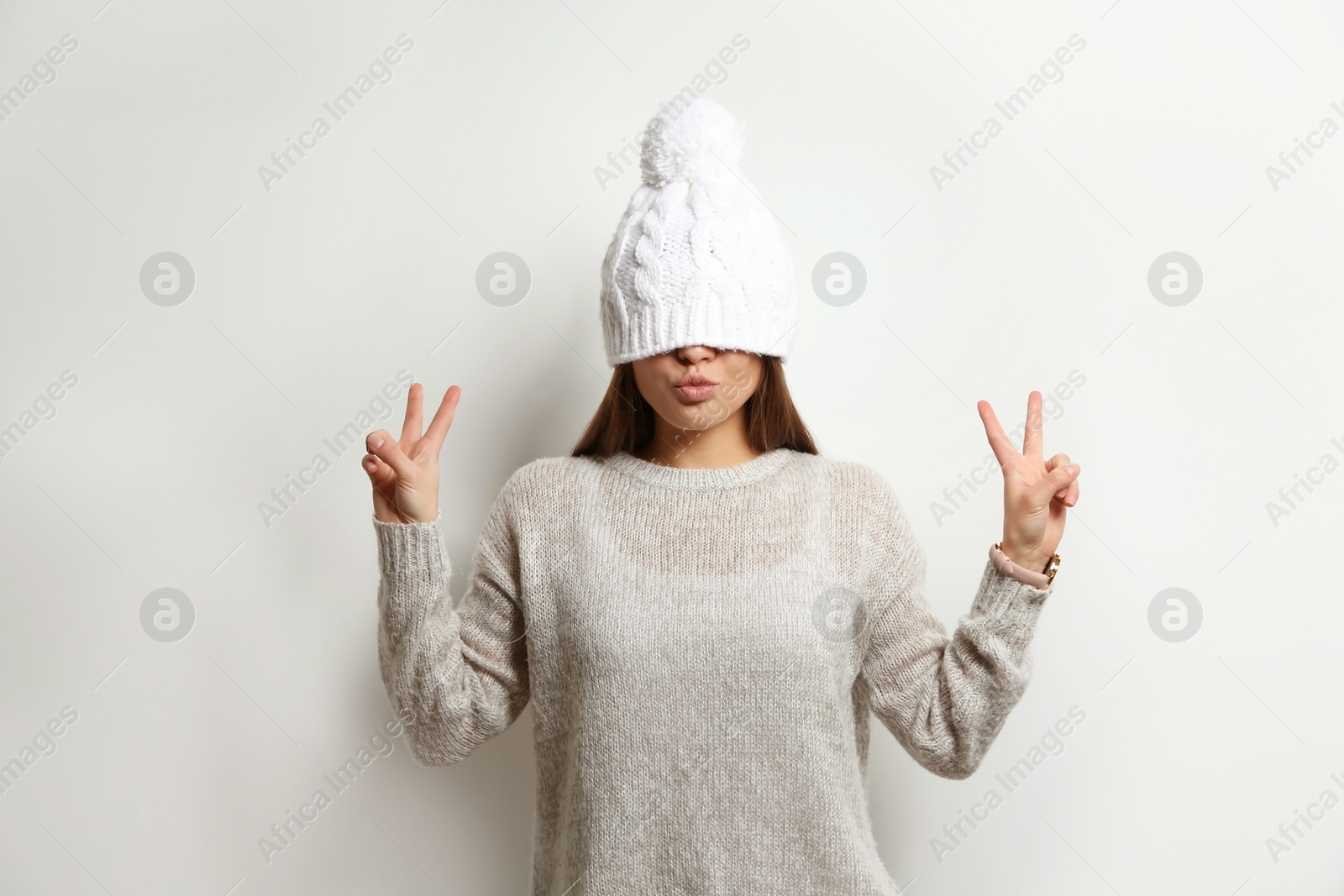 Photo of Beautiful young woman in warm sweater with hat on white background