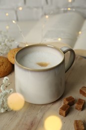 Photo of Cup of coffee, brown sugar and cookies on wooden table, bokeh effect