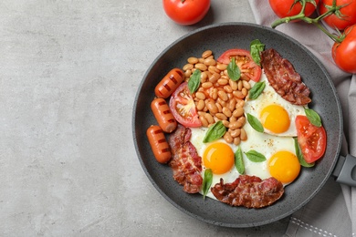 Photo of Delicious breakfast with fried eggs served on grey table, top view. Space for text