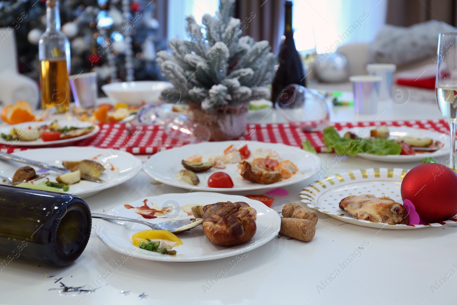 Photo of Dirty dishes on white table in room. Mess after new year party