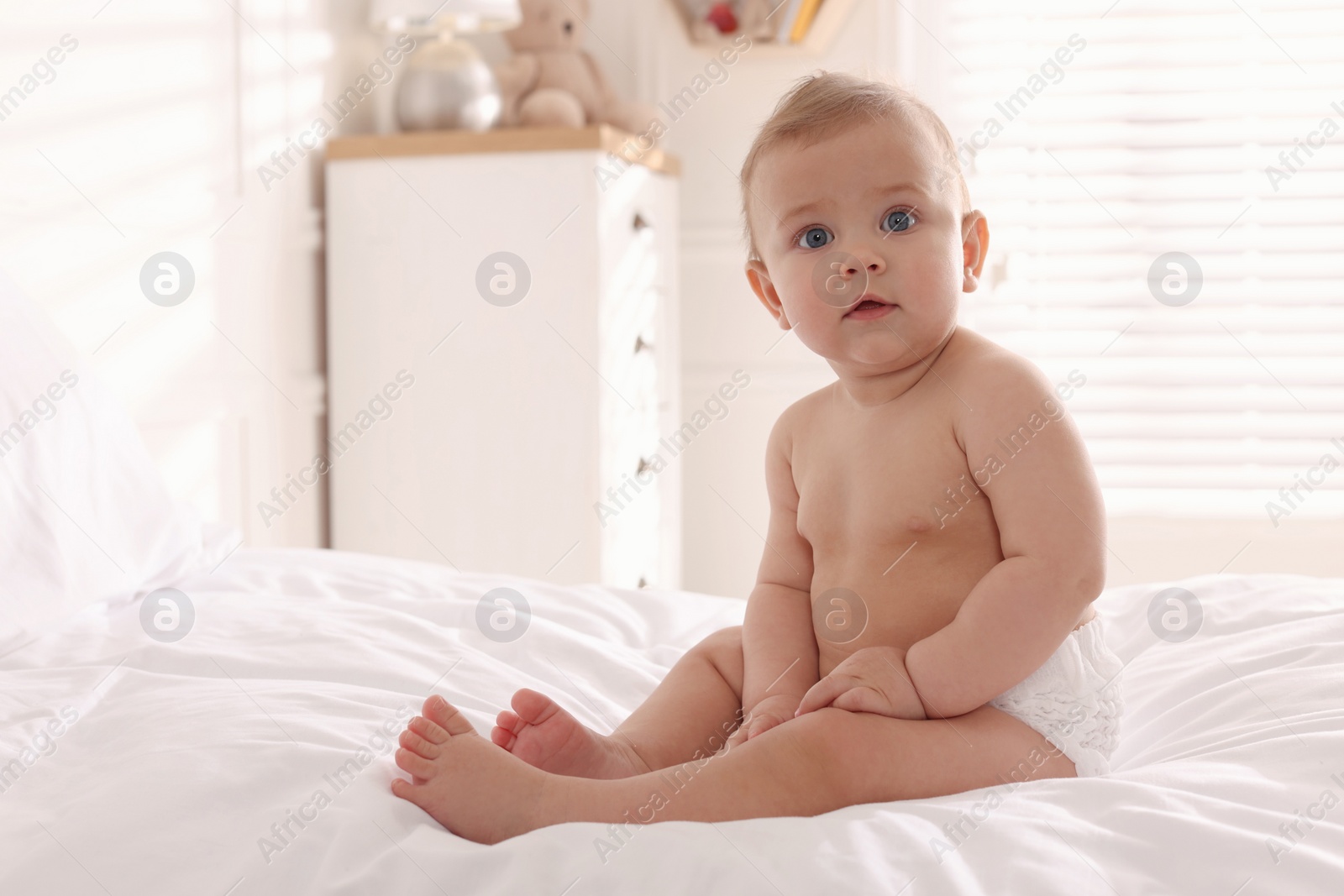 Photo of Cute little baby on bed at home. Space for text