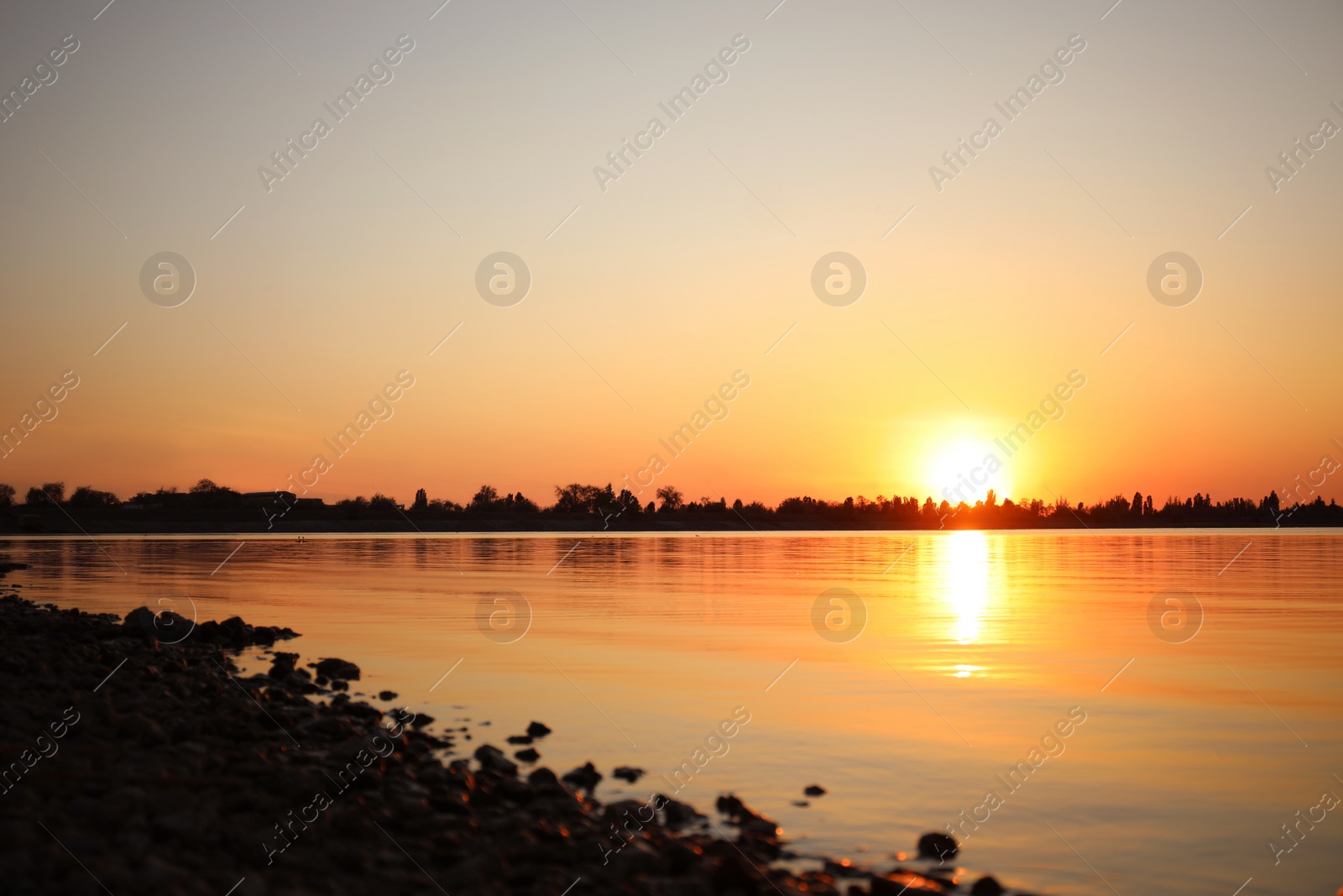 Photo of Picturesque view of rocky beach at sunset