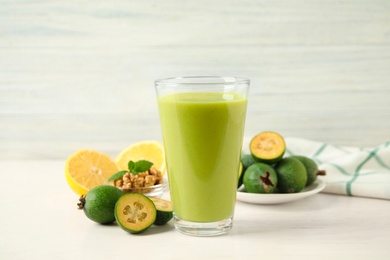 Photo of Fresh feijoa smoothie in glass on white table