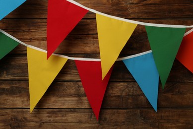 Photo of Buntings with colorful triangular flags on wooden background