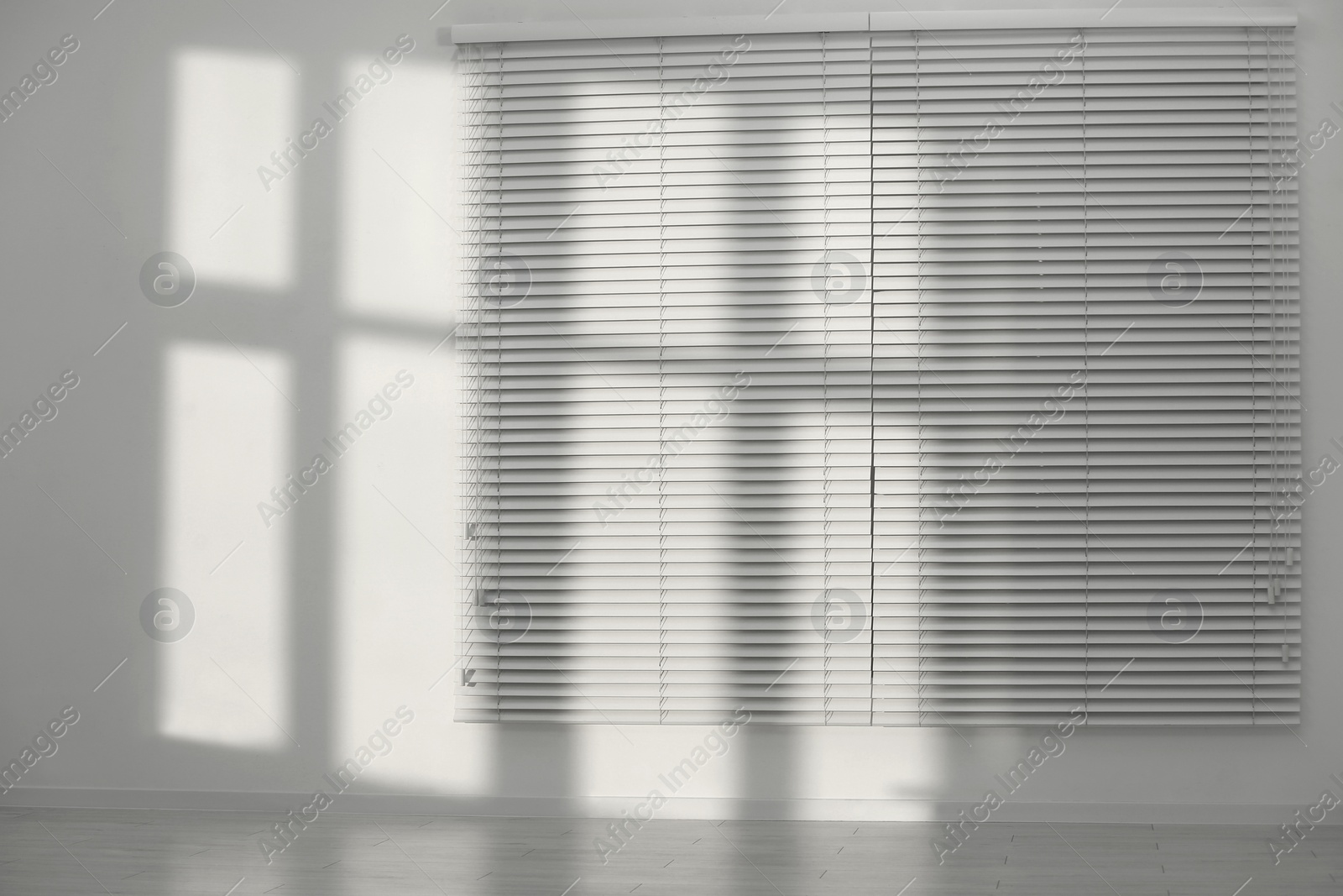 Photo of Light and shadows from window on wall indoors