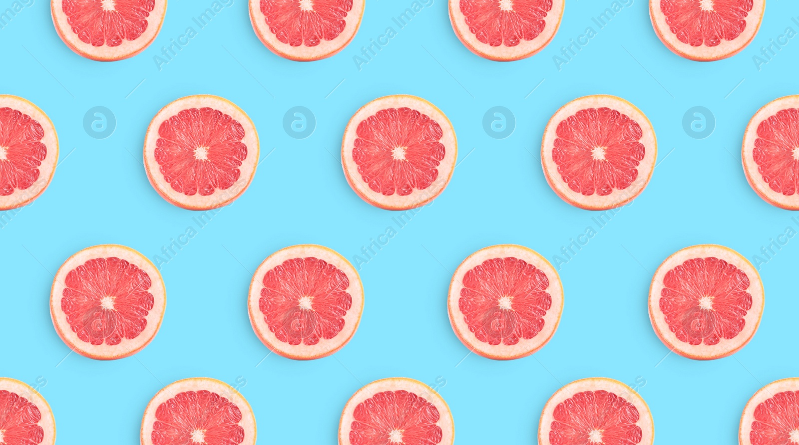 Image of Slices of grapefruits on light blue background, flat lay. Banner design