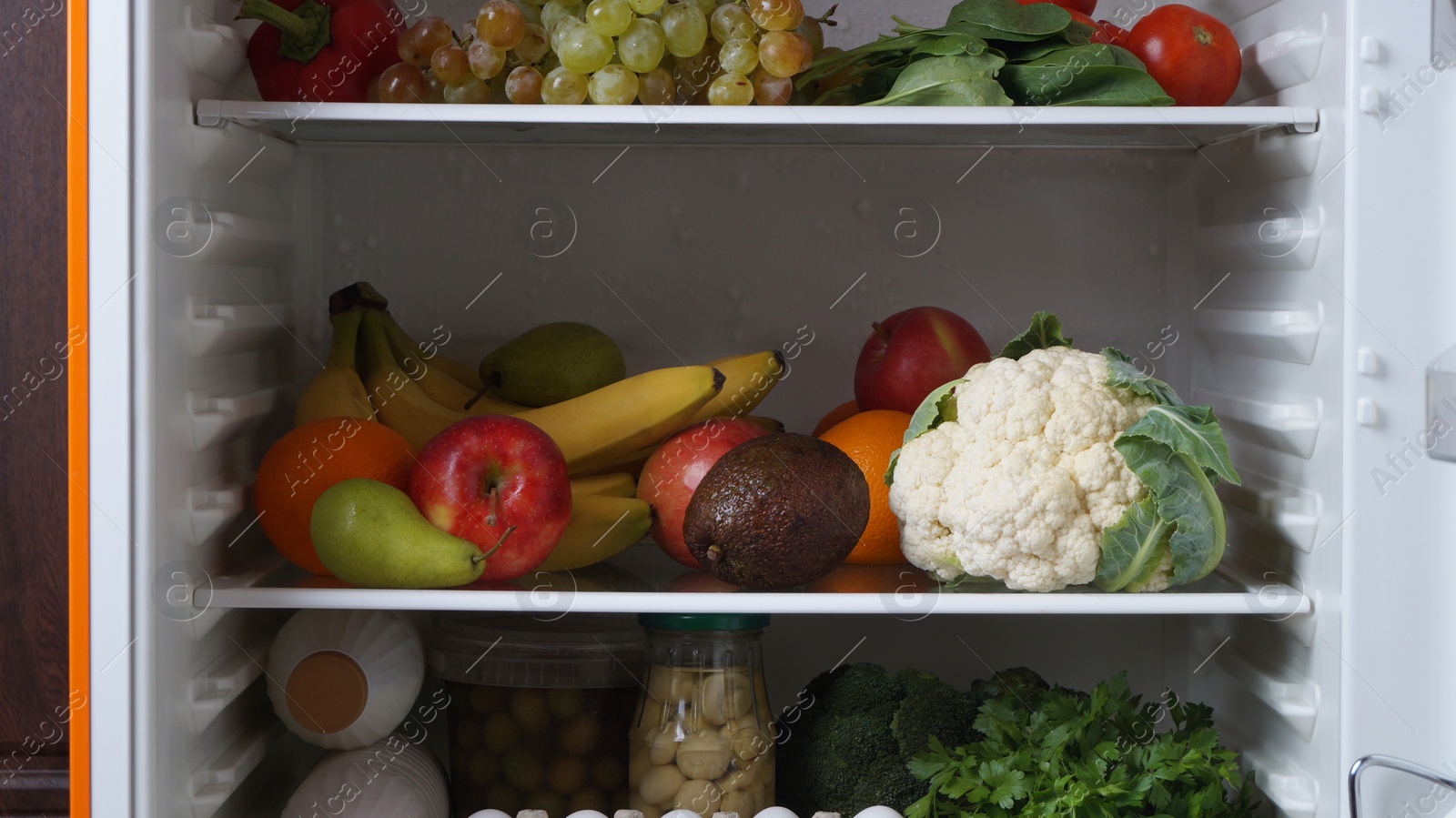 Photo of Open refrigerator full of many different products