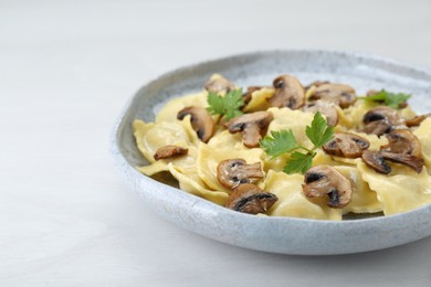 Photo of Delicious ravioli with mushrooms on white table, closeup